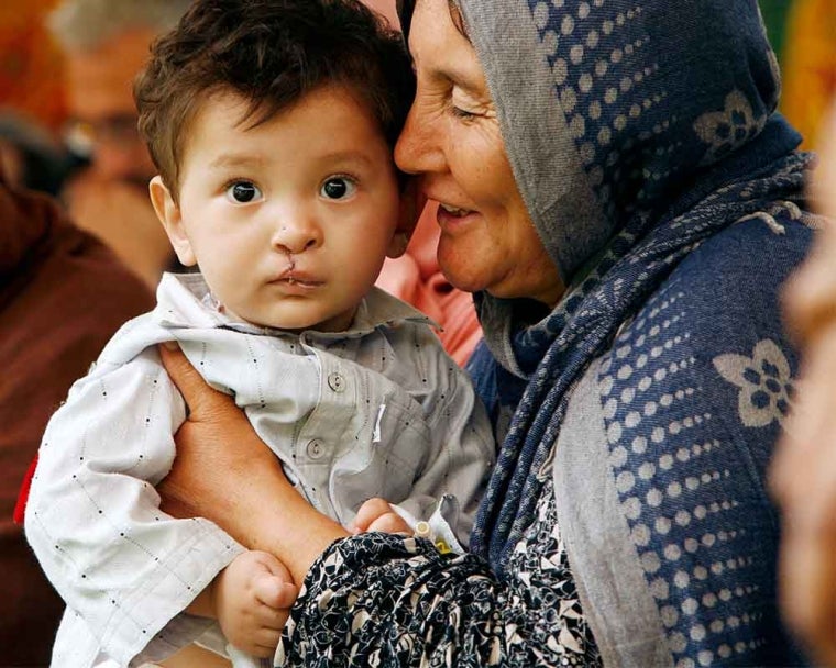 happy mother holds son after cleft surgery